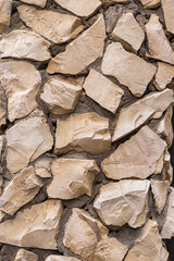 Decorative abstract background of a stone wall made of numerous small stones of different shapes. stone vertical background. natural stone texture.