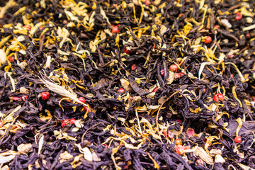 A tea blend of dry traditional tea leaves and petals, blue cornflower flowers. bright taste. organic drink. protection of the body, selective focus