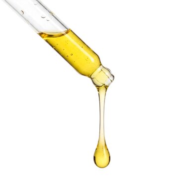 A yellow golden serum oil dripping from dropper isolated on white background	A yellow golden serum oil dripping from dropper isolated on white background	