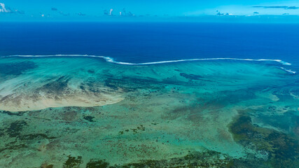 Obraz premium Aerial view of Mauritius island and Le Morne Brabant mountain with beautiful blue lagoon and underwater waterfall illusion background