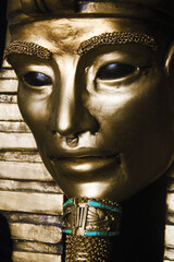 Golden pharaoh mask sculpture with turquoise accents, featuring alien-inspired eyes. A mysterious blend of ancient Egyptian symbolism and cosmic allure. Unique contemporary sculpture.