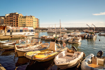 Scorcio del porto di Camogli con barche ormeggiate e luce dorata sul mare	
