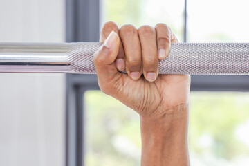 Close up hand women holding dumbbell on floor in gym with background. Object goal weightlifting bodybuilding. 