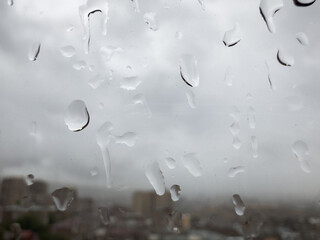 Raindrops on the window, rain in the city, cloudy weather, wet window after rain. High quality