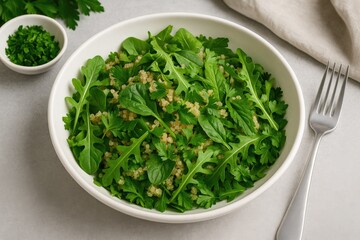 Fresh green mixed greens salad in white bowl with arugula and small blossoms, parsley garnish, fork alongside