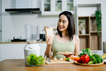 Asian woman holding bread while preparing breakfast with fresh vegetables. Concept of healthy lifestyle, nutrition, clean eating, and wellness