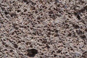 Porous volcanic stone texture, detailed close-up of natural rock surface with cavities. Perfect geology background for scientific, educational, construction or abstract design use