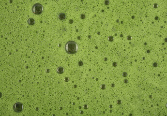Matcha foam with bubbles close up.