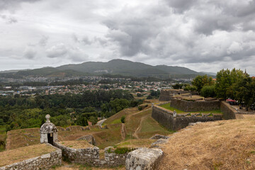 Fortress of Valença do Minho rising majestically with its ramparts and watchtowers, overlooking the city and mountains n a cloudy day, capturing the essence of Portugal's rich history