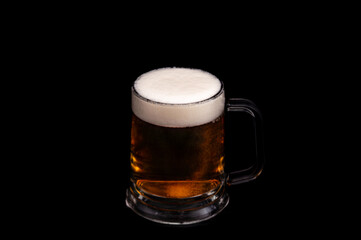 Dark beer in glass mug on black background – studio glassware
