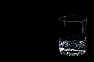 Empty glass on black background – minimalist studio setup