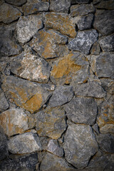 Rustic gray stone masonry vertical wall closeup