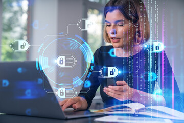 Woman working on laptop and smartphone with cybersecurity padlock graphics on office background, illustrating data protection concept in digital age.