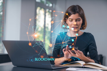 Woman using smartphone and laptop with blockchain technology concept network overlay on office background.