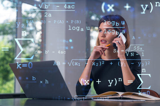 Woman analyzing complex math formulas on transparent screen concept with modern office background, using phone and laptop for data analysis tasks.
