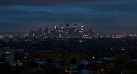 Tranquil urban night scene featuring illuminated buildings and forested foreground with fall colors