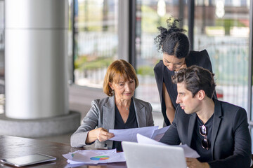 Group of managers or business workers share heir happiness after achieving project target. A moment of team's collective efforts in business workplace shared by members from different generations