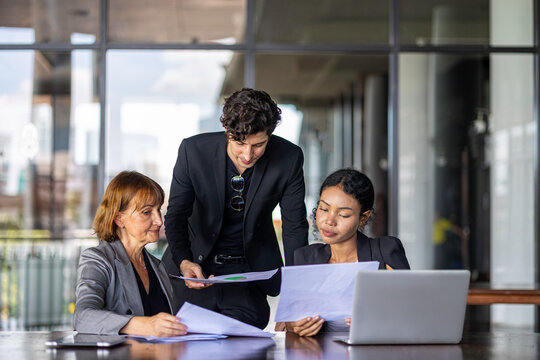 Group of managers or business workers share heir happiness after achieving project target. A moment of team's collective efforts in business workplace shared by members from different generations