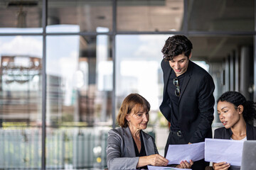 Group of managers or business workers share heir happiness after achieving project target. A moment of team's collective efforts in business workplace shared by members from different generations