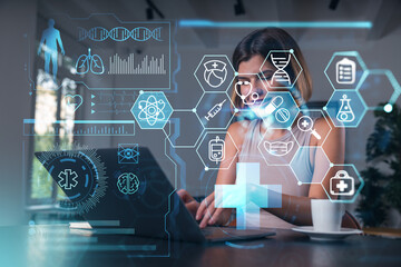 Woman using laptop with futuristic medical interface holograms around her in modern office background, healthcare technology concept scene.