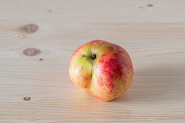 Ripe juicy red apple on a wooden desk.