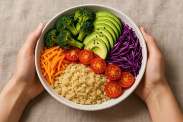 Colorful grain bowl with broccoli, avocado, cucumber, carrot, purple cabbage, cherry tomatoes, and quinoa