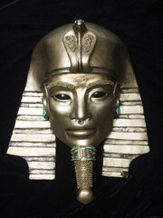 Golden pharaoh mask sculpture with turquoise accents, featuring alien-inspired eyes. A mysterious blend of ancient Egyptian symbolism and cosmic allure. Unique contemporary sculpture.