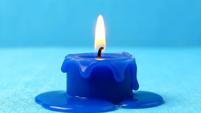 A single blue candle burns brightly and melts.