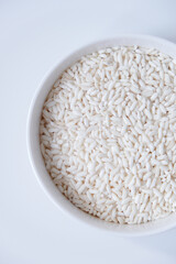 A bowl of white sticky rice grains isolated on white background