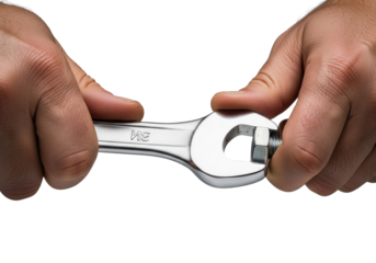 Strong adult male hands with callouses and grease turning a polished steel spanner wrench on a hexagonal bolt against a transparent studio background. Concept of skilled craftsmanship and technical
