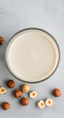  A top view of creamy hazelnut vegan milk presented with whole nuts for a natural and wholesome look