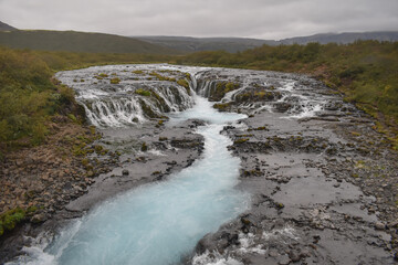 Blue waterfall on the river in cloudy weather, landscape