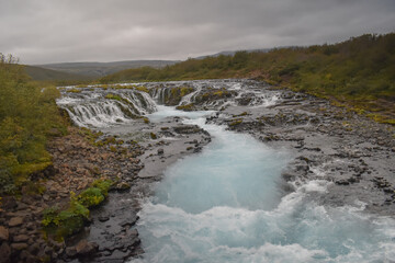 Blue waterfall on the river in cloudy weather, landscape and nature