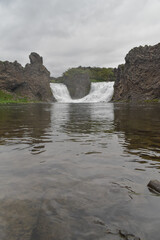 Double waterfall on the river in cloudy weather