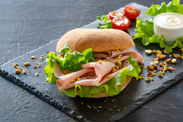 Sandwich with mortadella and pistachios on wooden table	