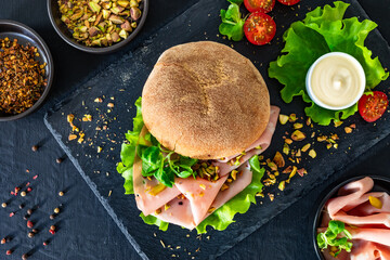 Sandwich with mortadella and pistachios on wooden table	