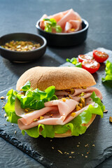 Sandwich with mortadella and pistachios on wooden table	