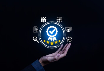 Business hand holding digital quality certification badge with five stars, check mark, and performance icons, symbolizing standard, trust, excellence, assurance, customer satisfaction, and success.