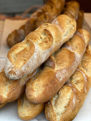 Freshly baked baguettes stacked in close-up, showcasing crisp crusts and soft interiors