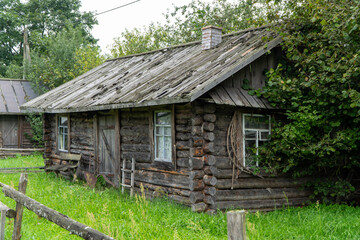 Old wooden house with a window covered with ivy, close-up