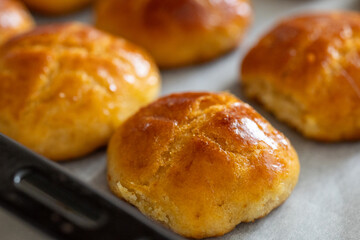 Close-Up of Mini Doughnut-Shaped Breads Baked on a Tray with Parchment Paper
