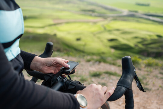 Young woman cyclist using gps navigator on gravel bike in countryside - Powered by Adobe