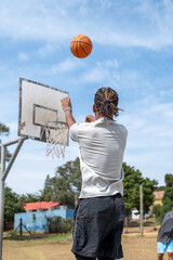 Young man seen shooting basketball towards hoop