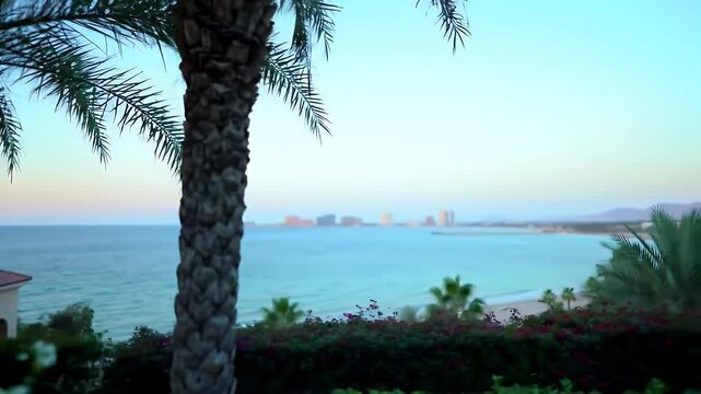 Static Wide Shot Captures a Tranquil Beach with Gentle Waves and Pastel Sky Framed by Palm Trees Against a Distant Cityscape Offering a Serene Coastal Panoramic View