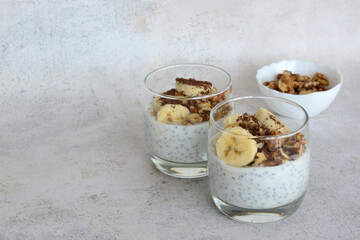 a healthy banana pudding with chia seeds and walnut in glasses copy space