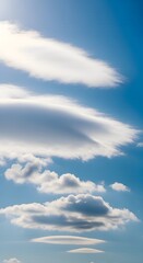 Lenticular and cumulus clouds stack in a brilliant blue sky with soft lighting
