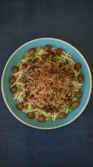 Delicious bowl of salad with fresh ingredients and crispy toppings served in a vibrant blue dish