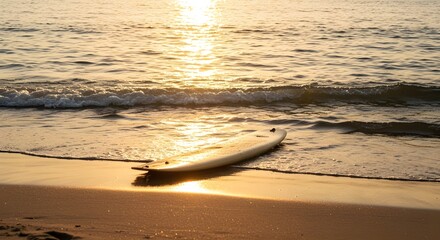 Golden sun setting over the ocean, casting a vibrant red reflection on the sand and water of the beach coast