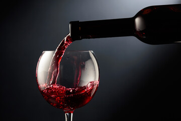 Pouring red wine into a wine glass.