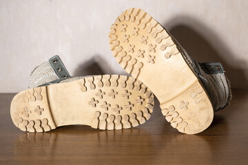 Close-up view of heavily worn winter boot sole showing eroded tread pattern. Slip hazard and footwear replacement concept.
